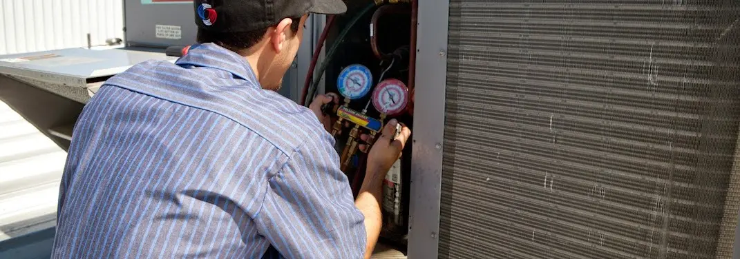 HVAC technician servicing a condenser unit in New Hope